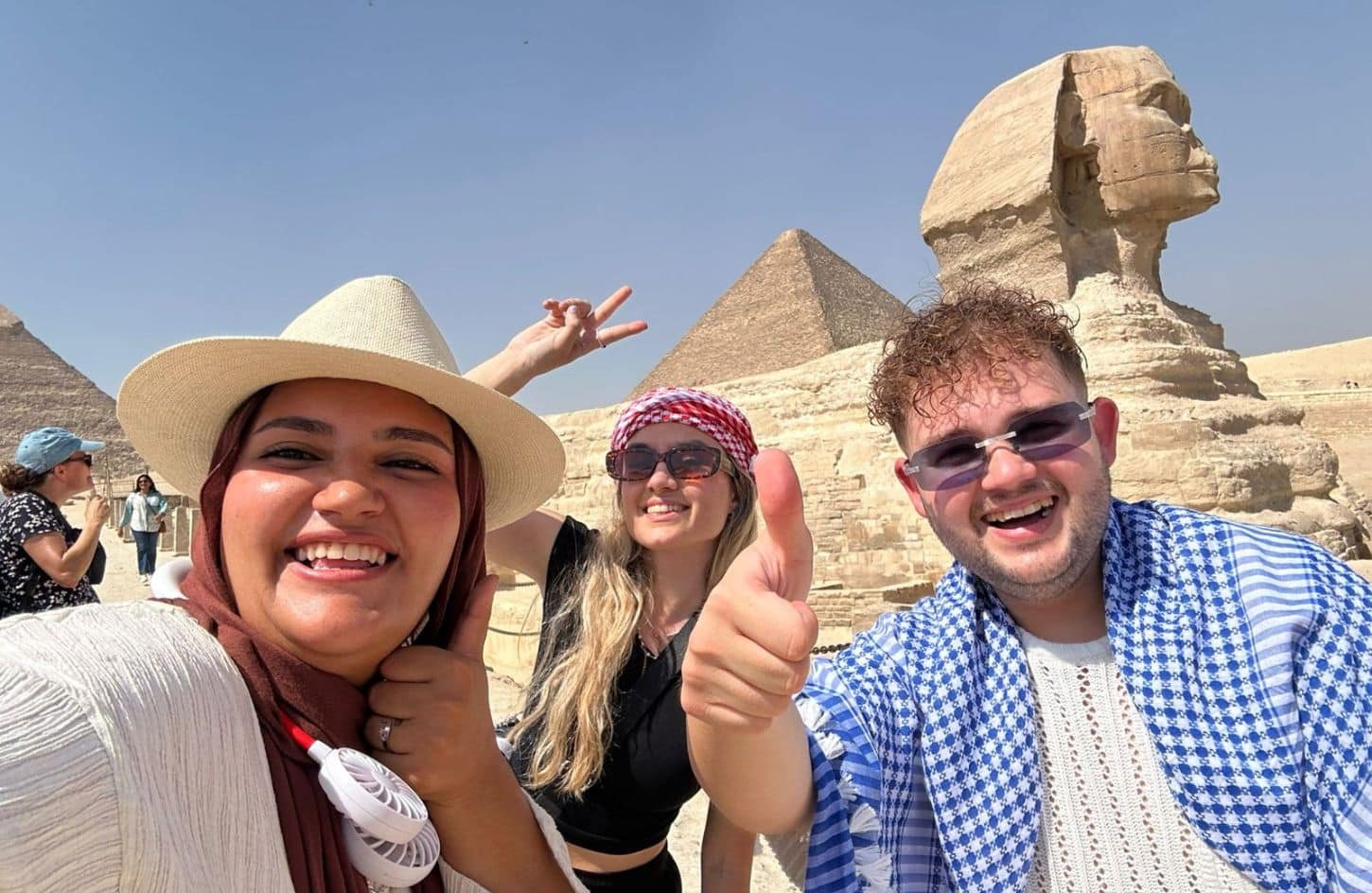 a wonderful shot of a couple with our friendly guide in front of the sphinx