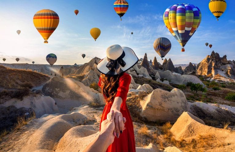A wonderful shot of a tourist in Cappadocia Turkey with hot air balloons