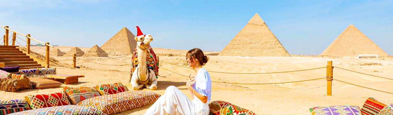 A wonderful shot of a tourist in front of the Giza Pyramids at Christmas time