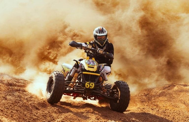 a wonderful shot of a tourist in the pyramids while riding a quad bike