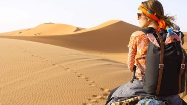 A wonderful photo of a solo female traveler in the Arabian Desert