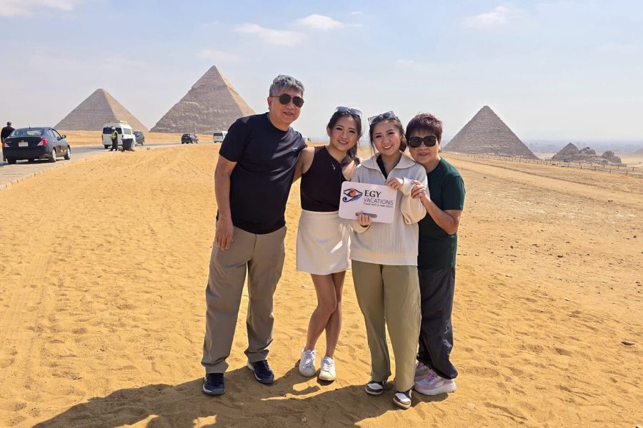 Family exploring Giza pyramids in Cairo, Egypt. Their sign reads: 