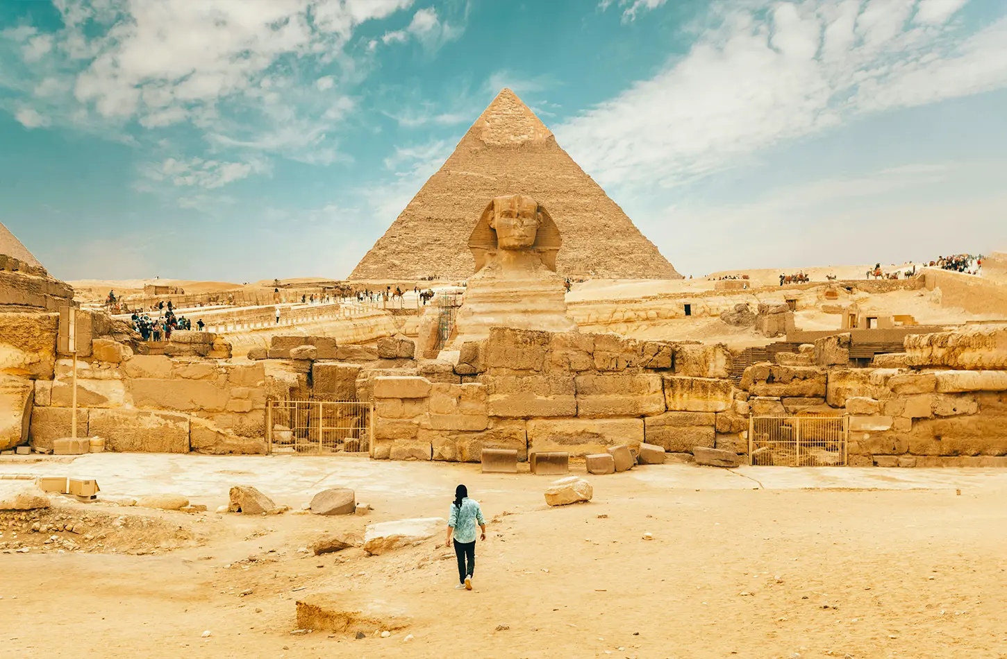 A man walks near the Great Sphinx, showcasing its iconic presence in the landscape of ancient Egypt.