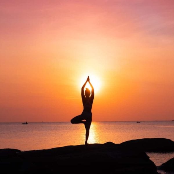 A wonderful shot of a girl meditating in front of the sea