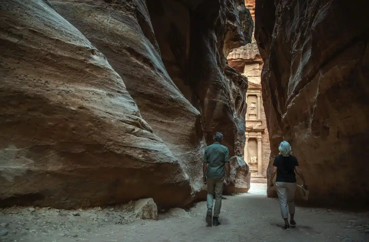 Your Guide to the Best Time to Visit Jordan 2 Best Time to Visit Jordan featuring two tourists walking through the narrow Siq canyon toward Al-Khazneh (The Treasury) in Petra