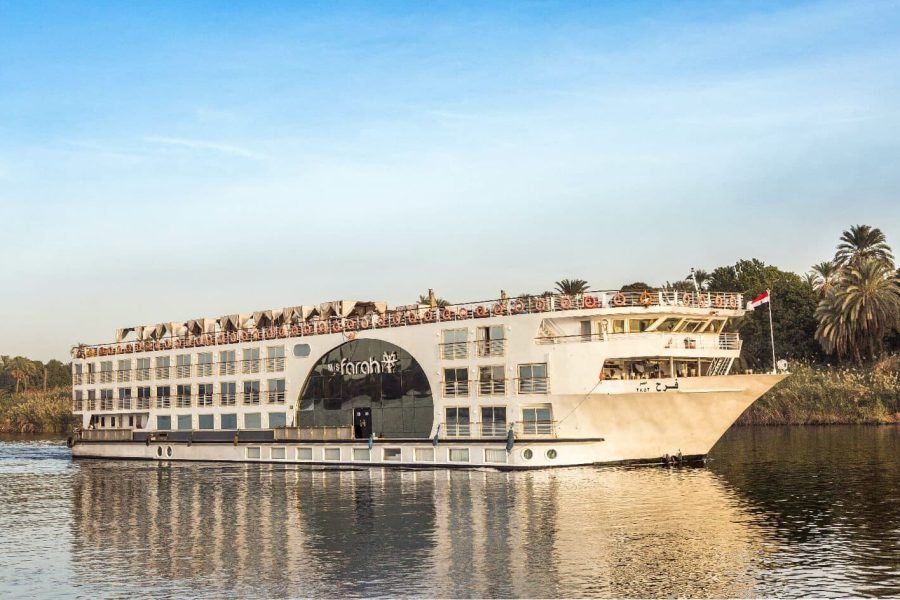 The Farah Nile Cruise ship sailing past palm trees on the water, showcasing its modern design