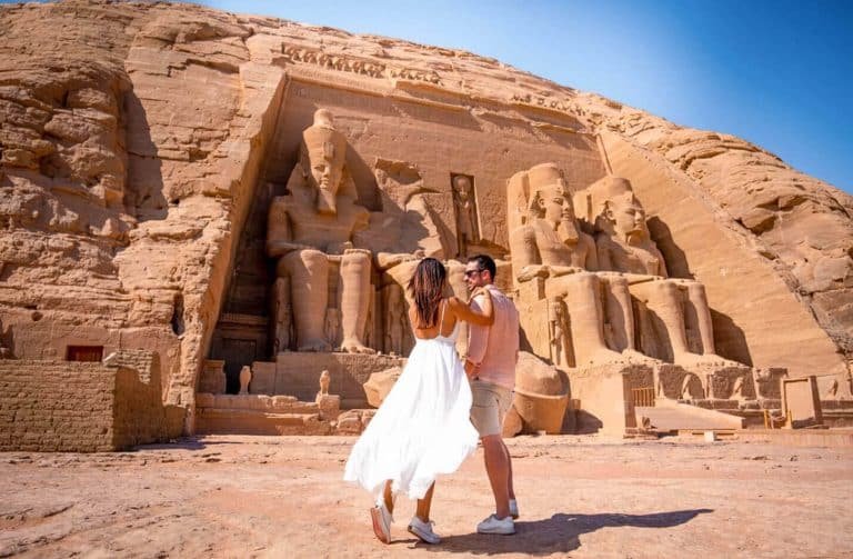 a photo of a couple in front of abu simbel temple in aswan