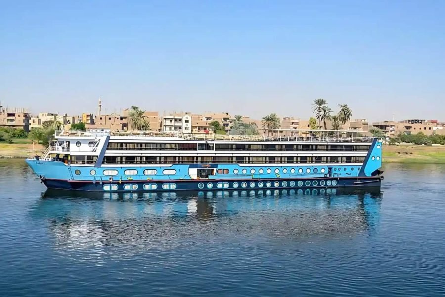 Full exterior view of the bright blue Magic Nile Cruise vessel sailing on the Nile River.