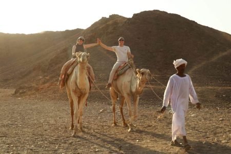 a distinctive shot of a couple riding camels in marsa alam