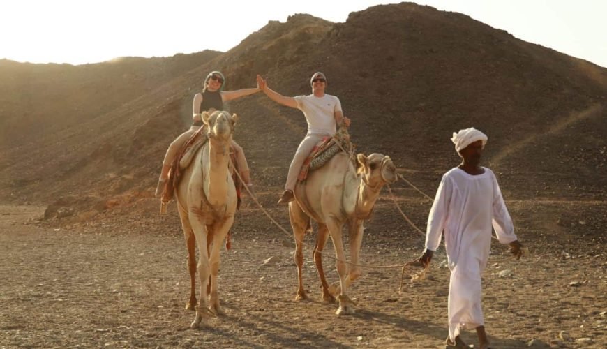 a distinctive shot of a couple riding camels in marsa alam