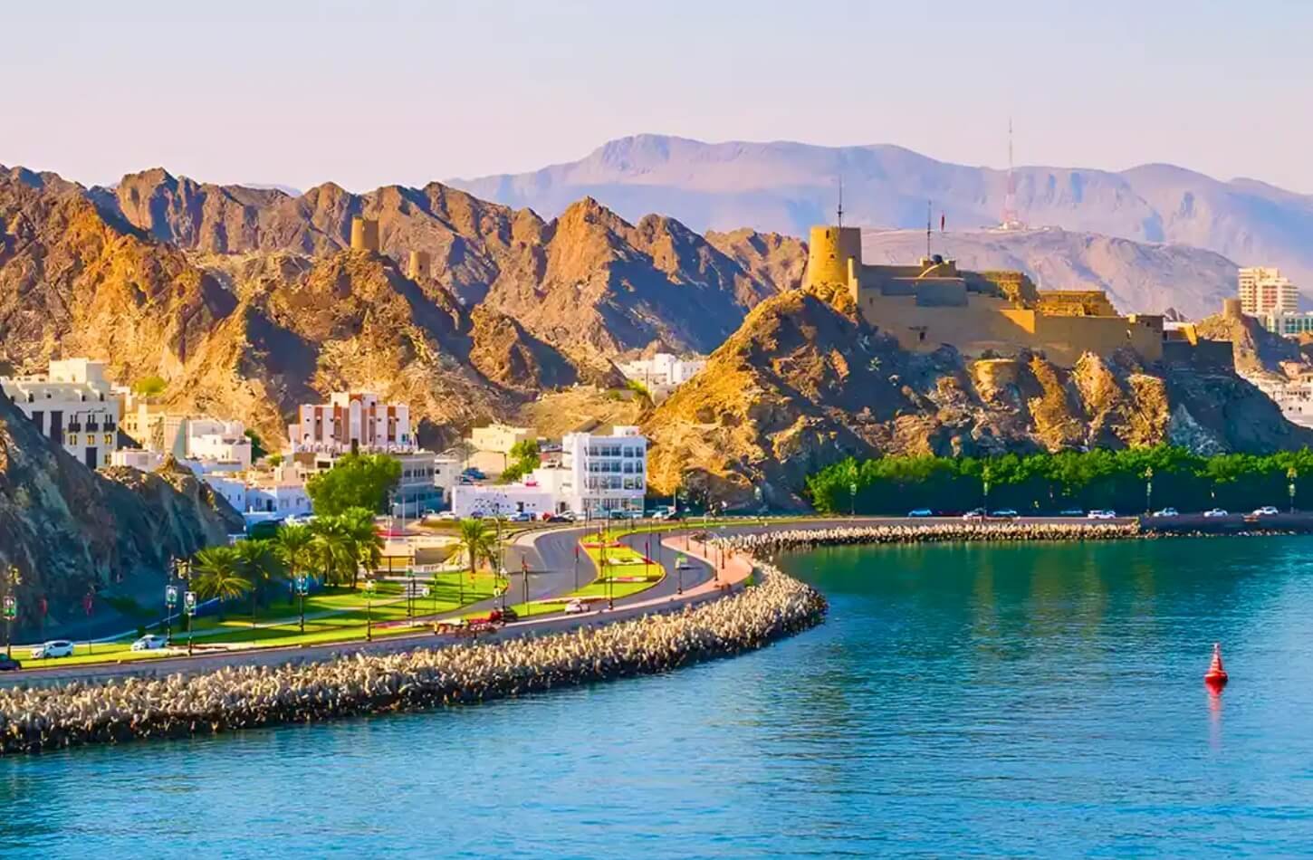 Beautiful seaside landscape of Muscat, Oman with rocky hills and a fort.