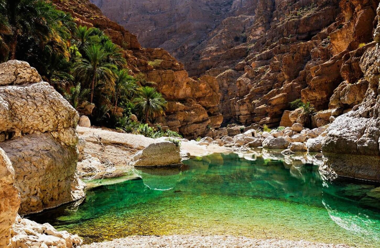 Natural rock pool oasis in a narrow Wadi gorge, a hidden gem of Oman nature.