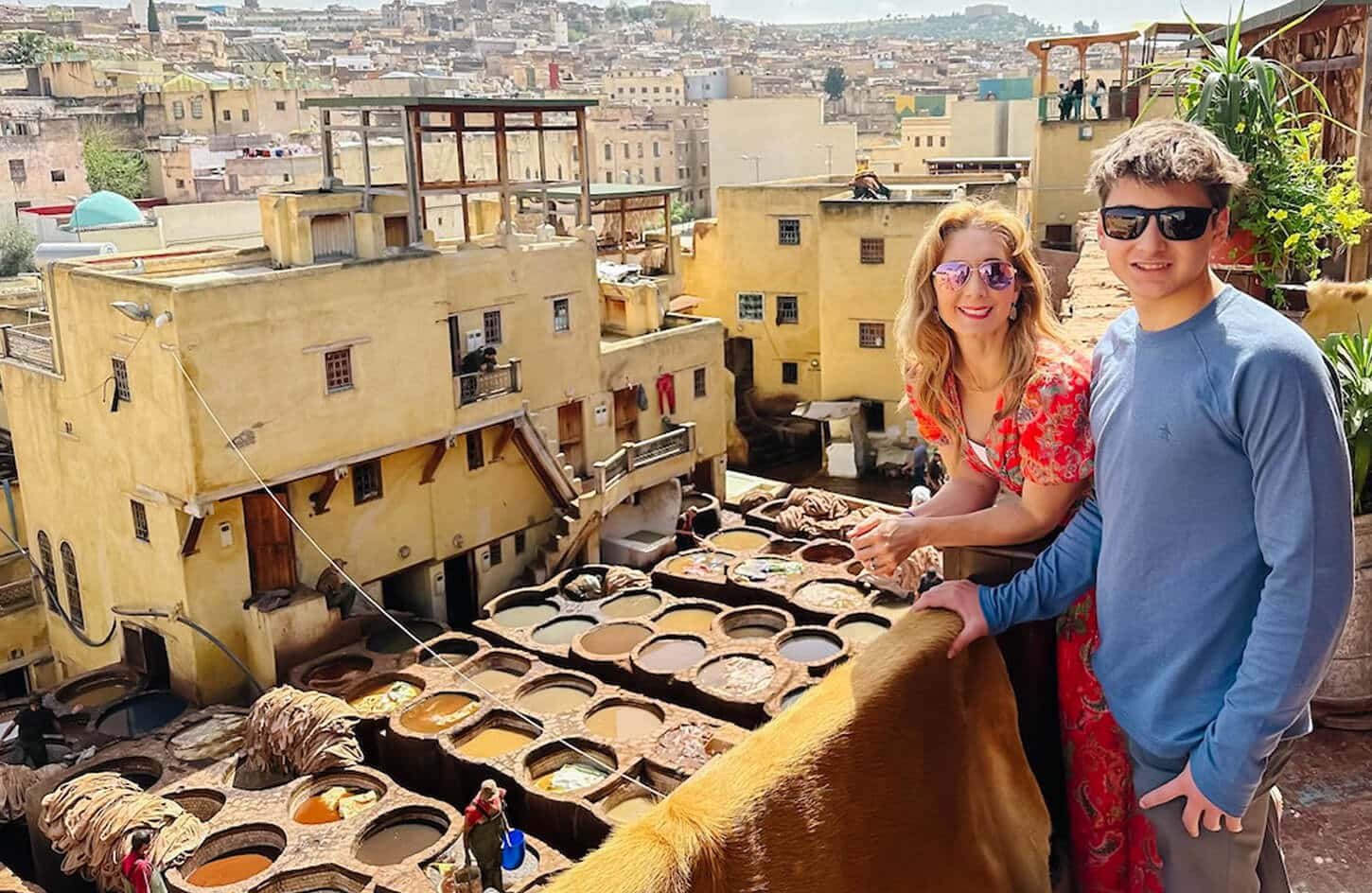 Tourist couple on a rooftop overlooking the dyeing vats of the famous Fez Chouara Tannery in Morocco.