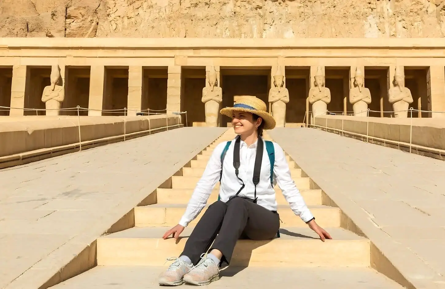 A stunning image of a girl sitting on the steps of Hatshepsuts temple